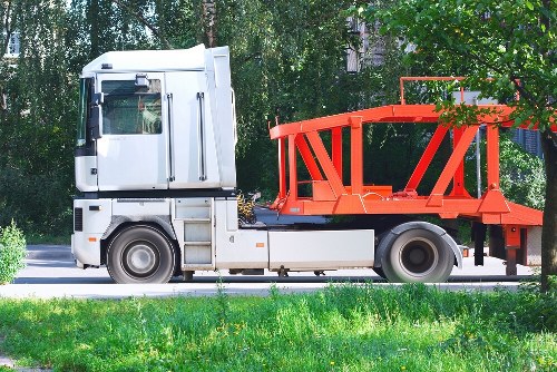 Waste collection vehicle and labelled bins at a commercial site